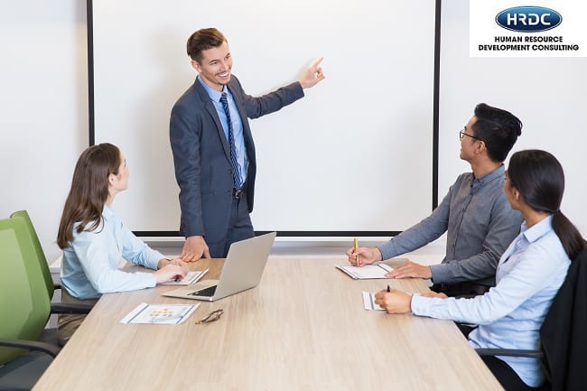 Happy Business Coach Consulting Team In Boardroom